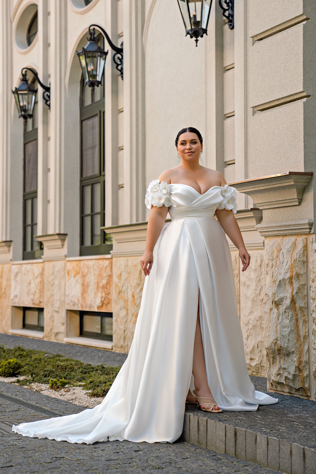 White A-line wedding dress with off-shoulder floral sleeves, sweetheart neckline, front slit, and train