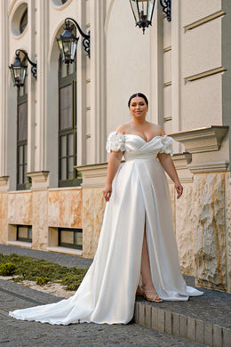 White A-line wedding dress with off-shoulder floral sleeves, sweetheart neckline, front slit, and train