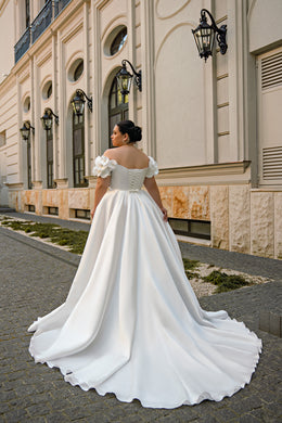 White wedding dress with floral off-shoulder sleeves, lace-up back, full A-line skirt, and long train