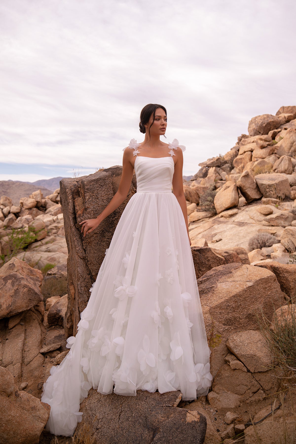 Ivory A-line wedding dress with a ruched bodice, floral shoulder straps, and 3D floral tulle skirt