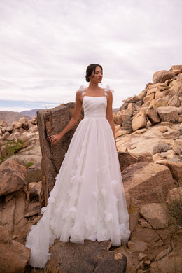 Ivory A-line wedding dress with a ruched bodice, floral shoulder straps, and 3D floral tulle skirt