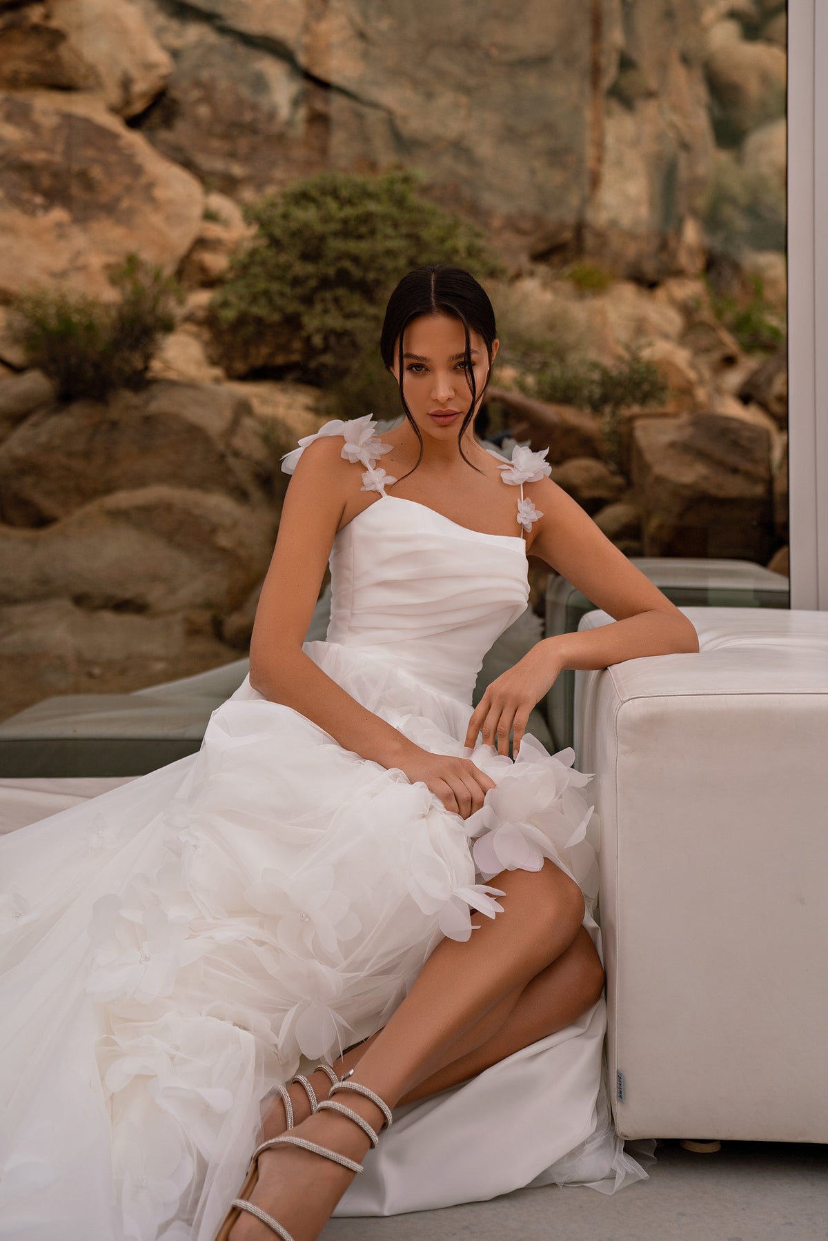 Ivory wedding dress with a ruched bodice, floral shoulder appliqués, and a high side slit