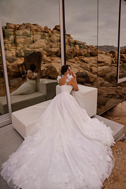 Open-back ivory wedding dress with floral shoulder appliqués, a full tulle skirt, and long chapel train