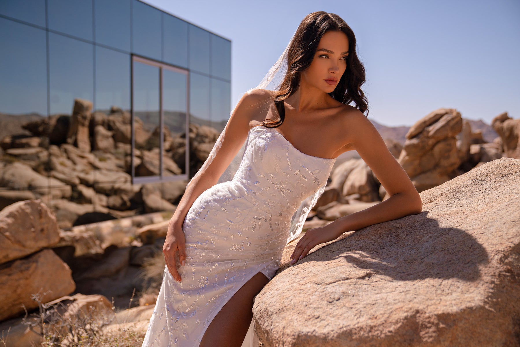 Fitted sheath wedding dress with thin straps, shimmering embroidery, and a high front slit