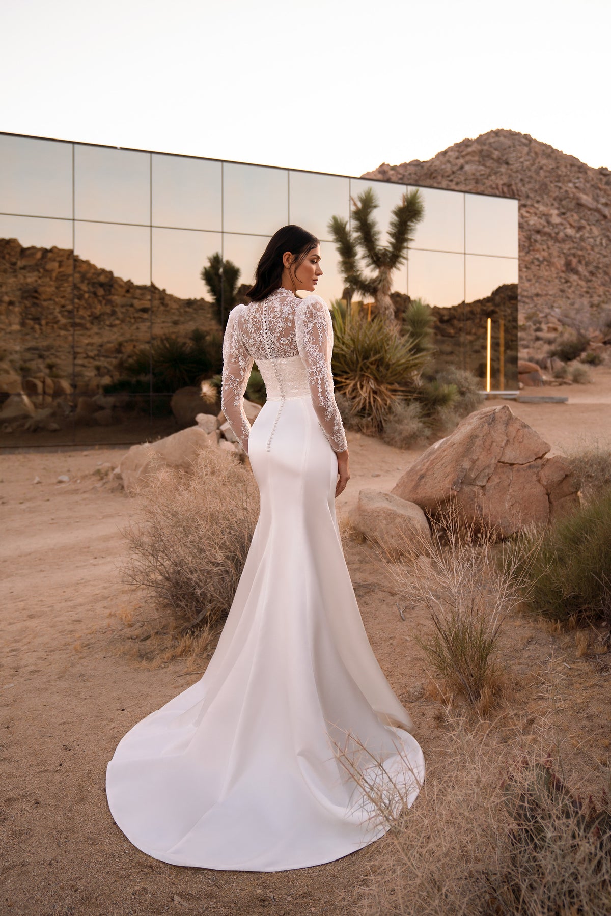 Ivory mermaid wedding dress with long floral lace sleeves, fitted back, and a sweeping train