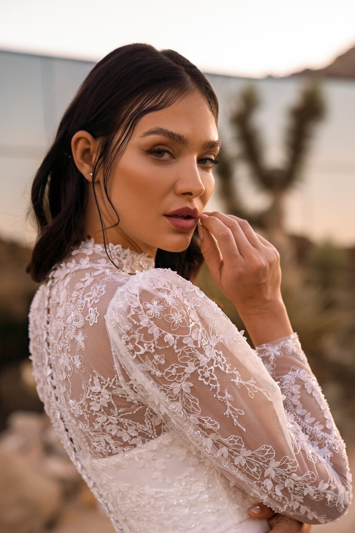 Close-up of floral lace sleeves and sheer embroidered detailing on an ivory wedding dress