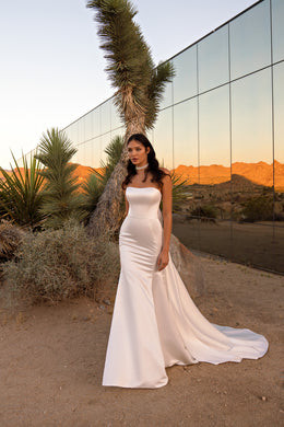 Sleeveless ivory wedding dress with a straight neckline, fitted silhouette, and long train