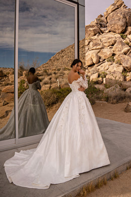 Ivory wedding dress with an off-the-shoulder lace back, full ball gown skirt, and sweeping train