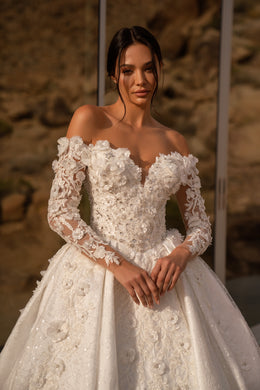 Close-up of a wedding dress bodice with floral lace appliqués, beadwork, and off-the-shoulder sleeves