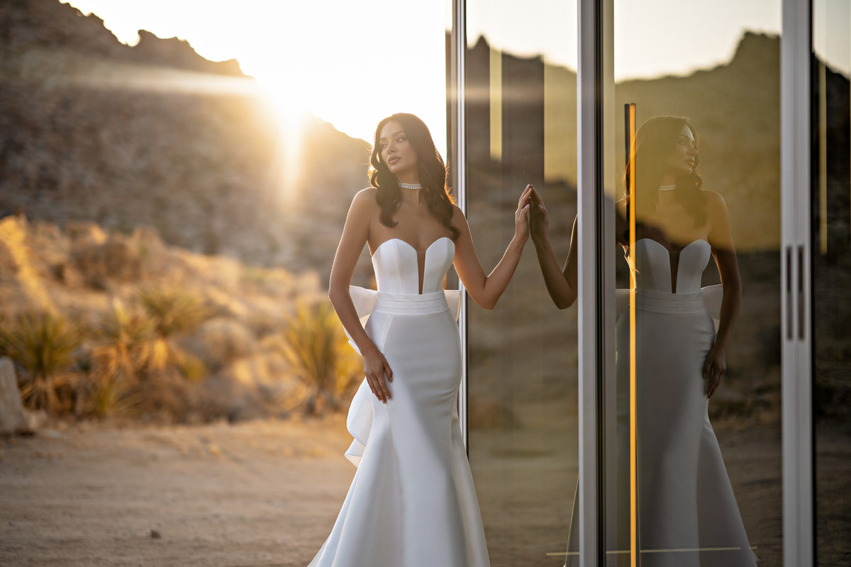 Plunging strapless neckline and sculpted mermaid silhouette on a white wedding dress