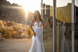 Plunging strapless neckline and sculpted mermaid silhouette on a white wedding dress