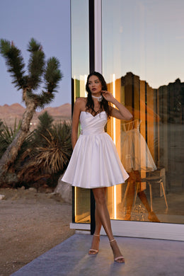 Ivory strapless wedding dress with a draped bodice and short, full satin skirt