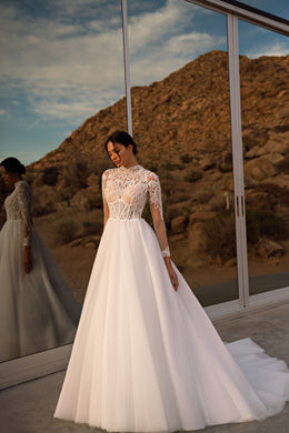 Ivory A-line wedding dress with a high lace neckline, fitted lace bodice, and full flowing skirt