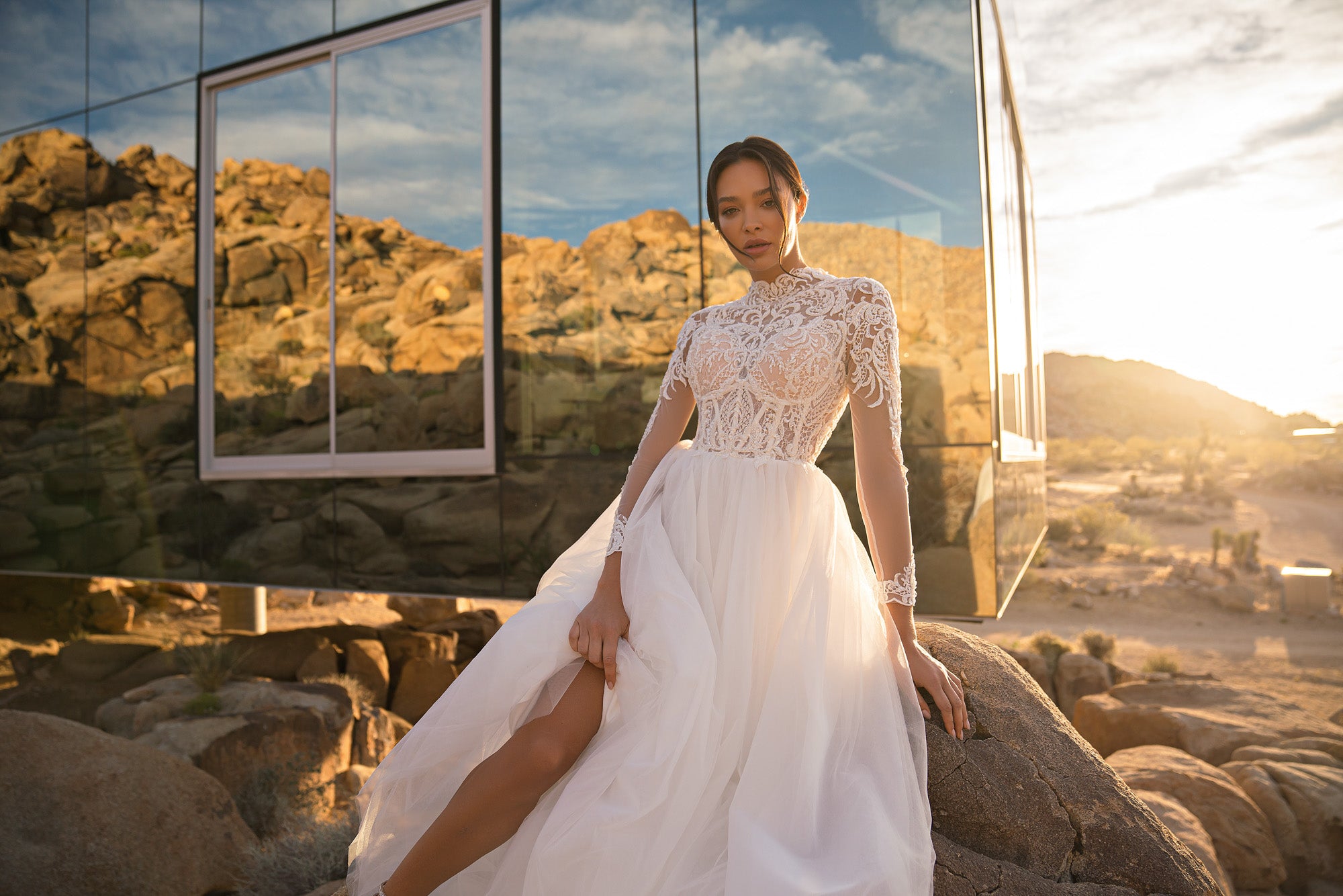 Ivory wedding dress with an intricate high-neck lace bodice, short sleeves, and a flowing skirt with slit
