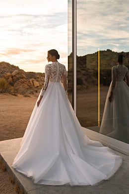Lace-back ivory wedding dress with a fitted bodice, full A-line skirt, and extended train