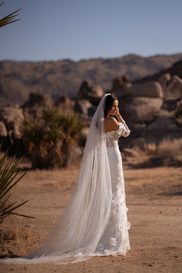 Long-train ivory mermaid wedding dress shown beneath a floor-length sheer veil