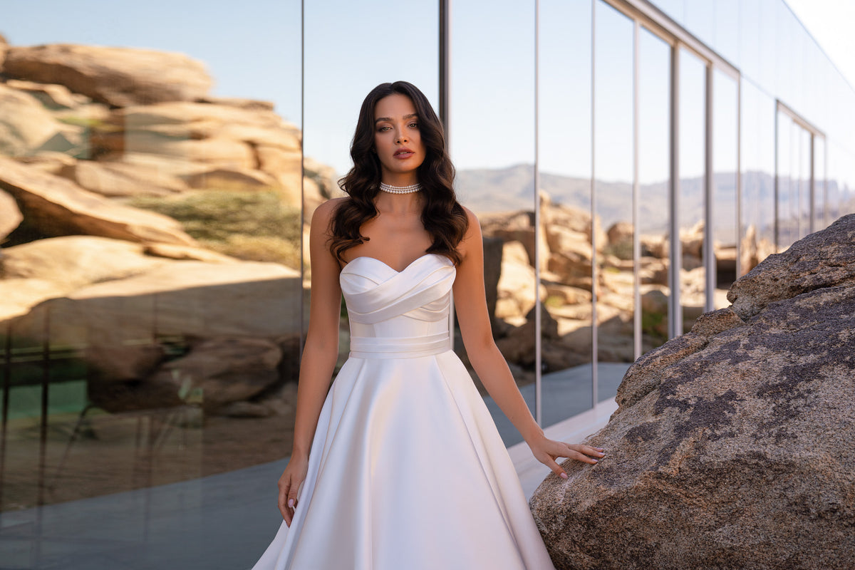 Strapless draped bodice and defined waist on a white A-line wedding dress