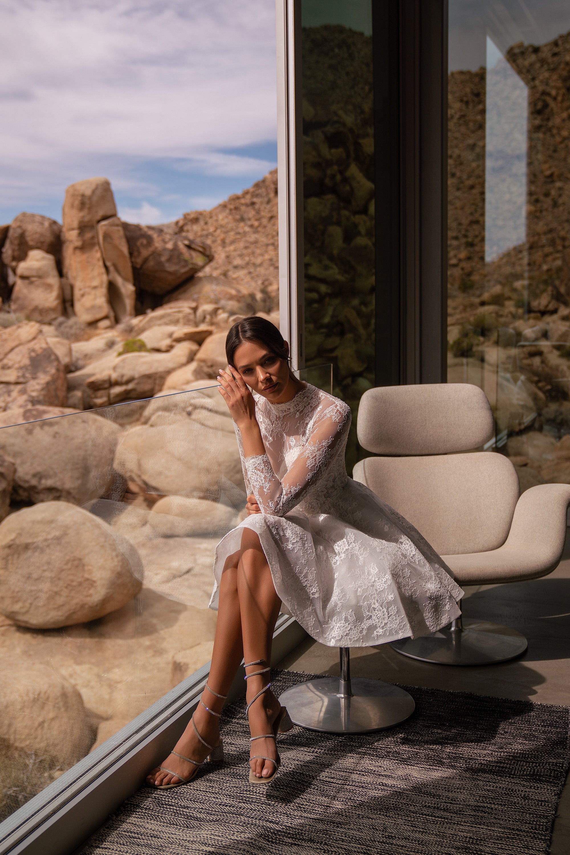 Long-sleeve lace wedding dress with a high neckline, fitted bodice, and flared knee-length skirt