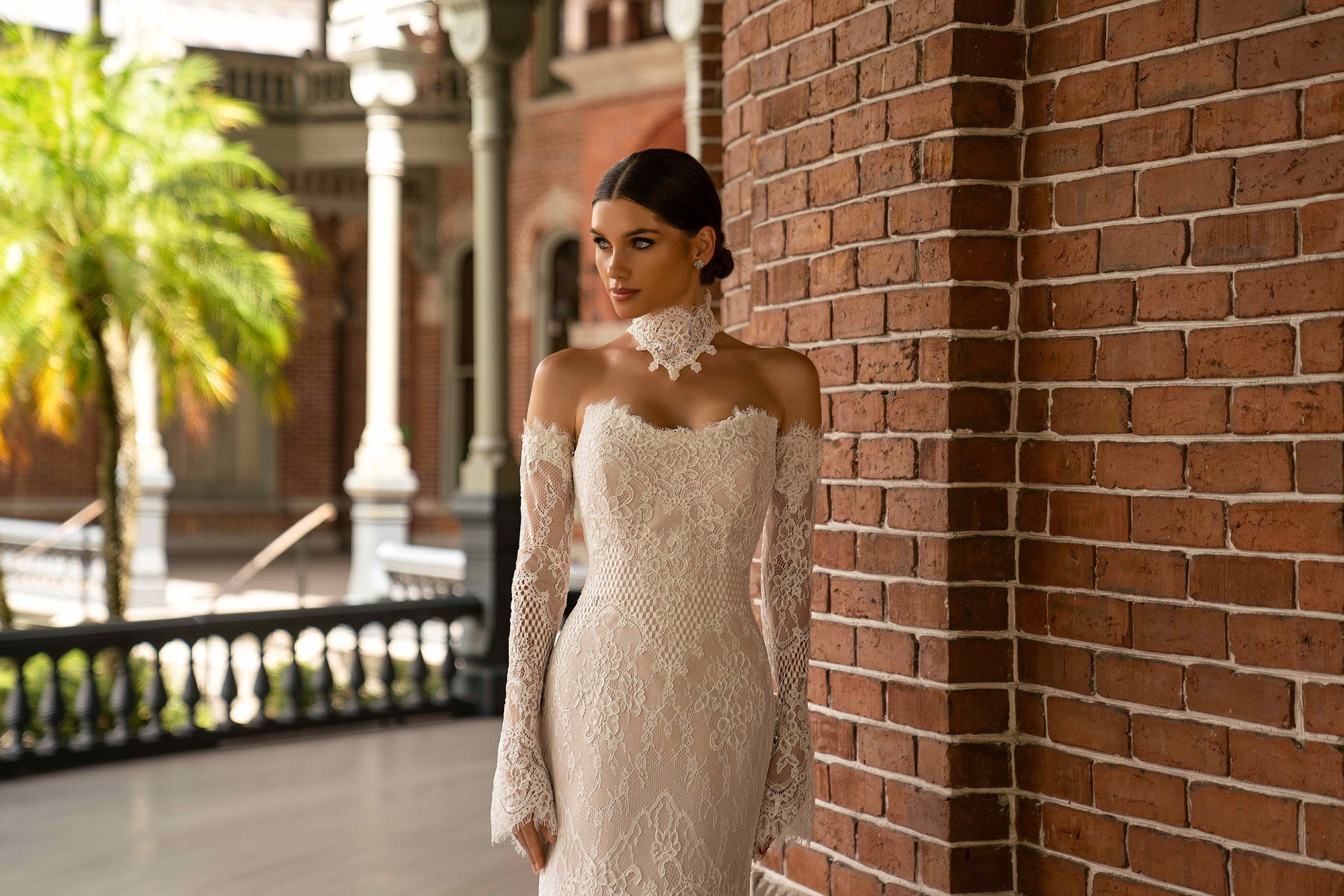 Close-up of an ivory lace wedding dress with fitted long sleeves and an off-the-shoulder neckline
