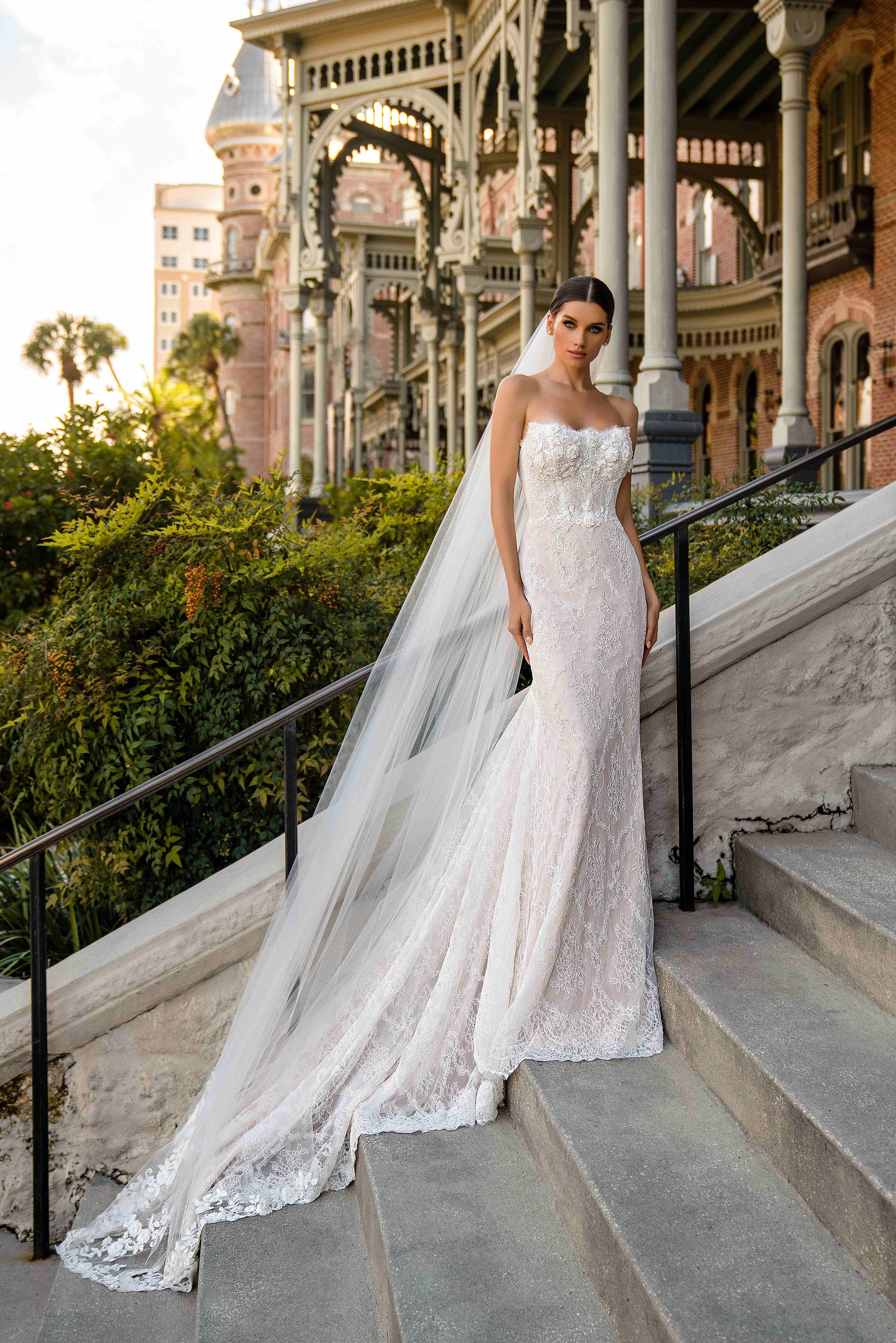 Ivory strapless mermaid wedding dress with a sparkling lace bodice and sweeping scalloped train