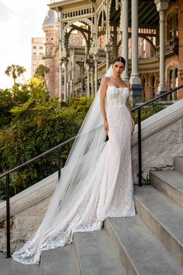 Ivory strapless mermaid wedding dress with a sparkling lace bodice and sweeping scalloped train