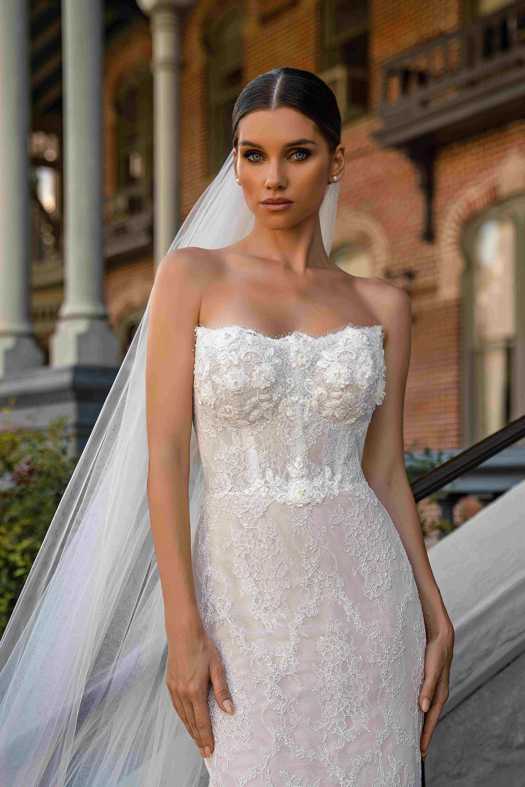 Close-up of an ivory strapless wedding dress with a beaded lace bodice and fitted mermaid silhouette