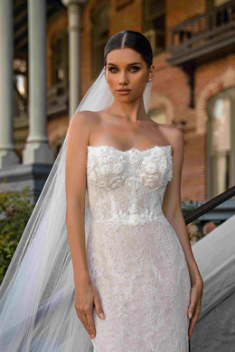 Close-up of an ivory strapless wedding dress with a beaded lace bodice and fitted mermaid silhouette