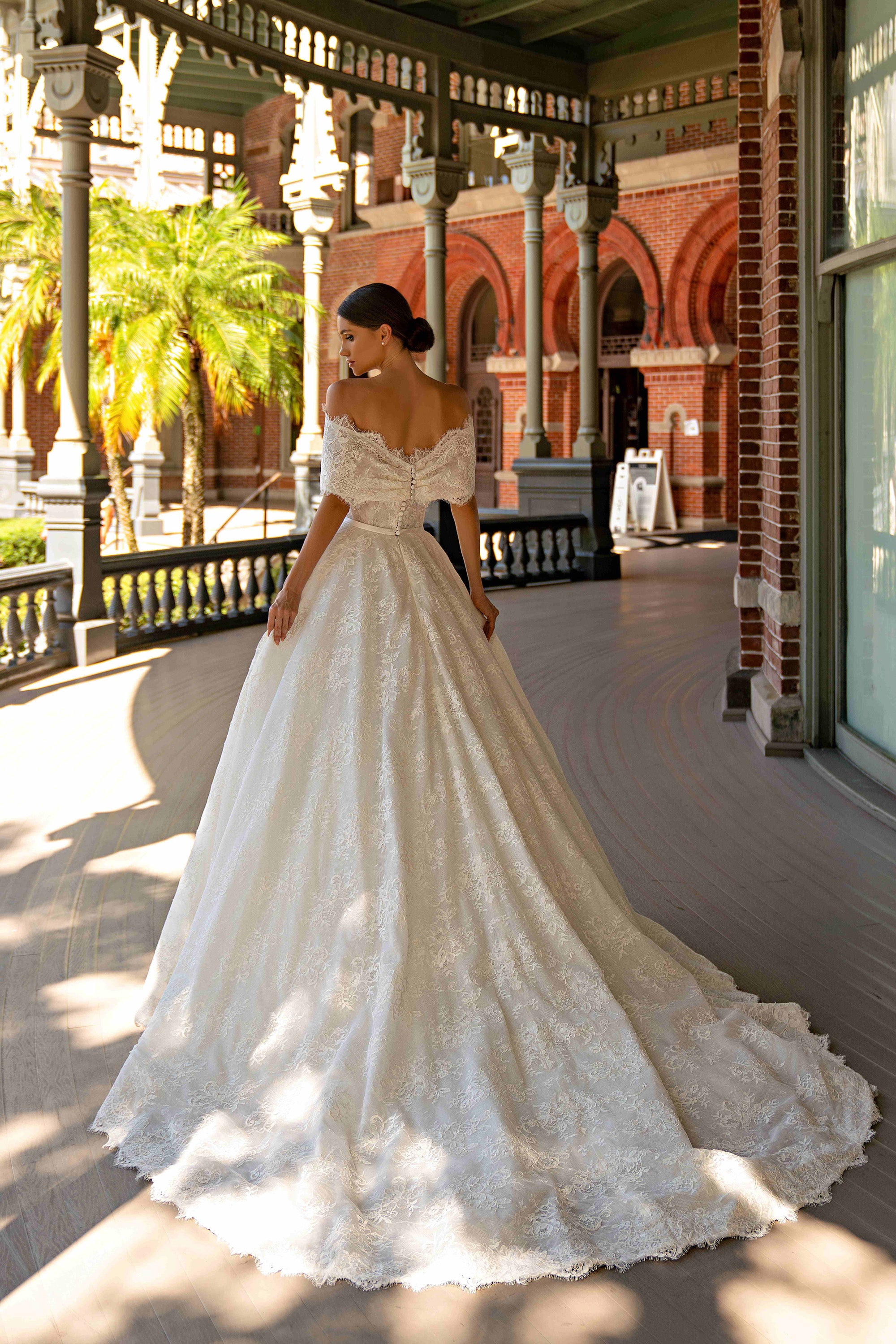 Lace off-shoulder back and extended train on an ivory A-line wedding dress