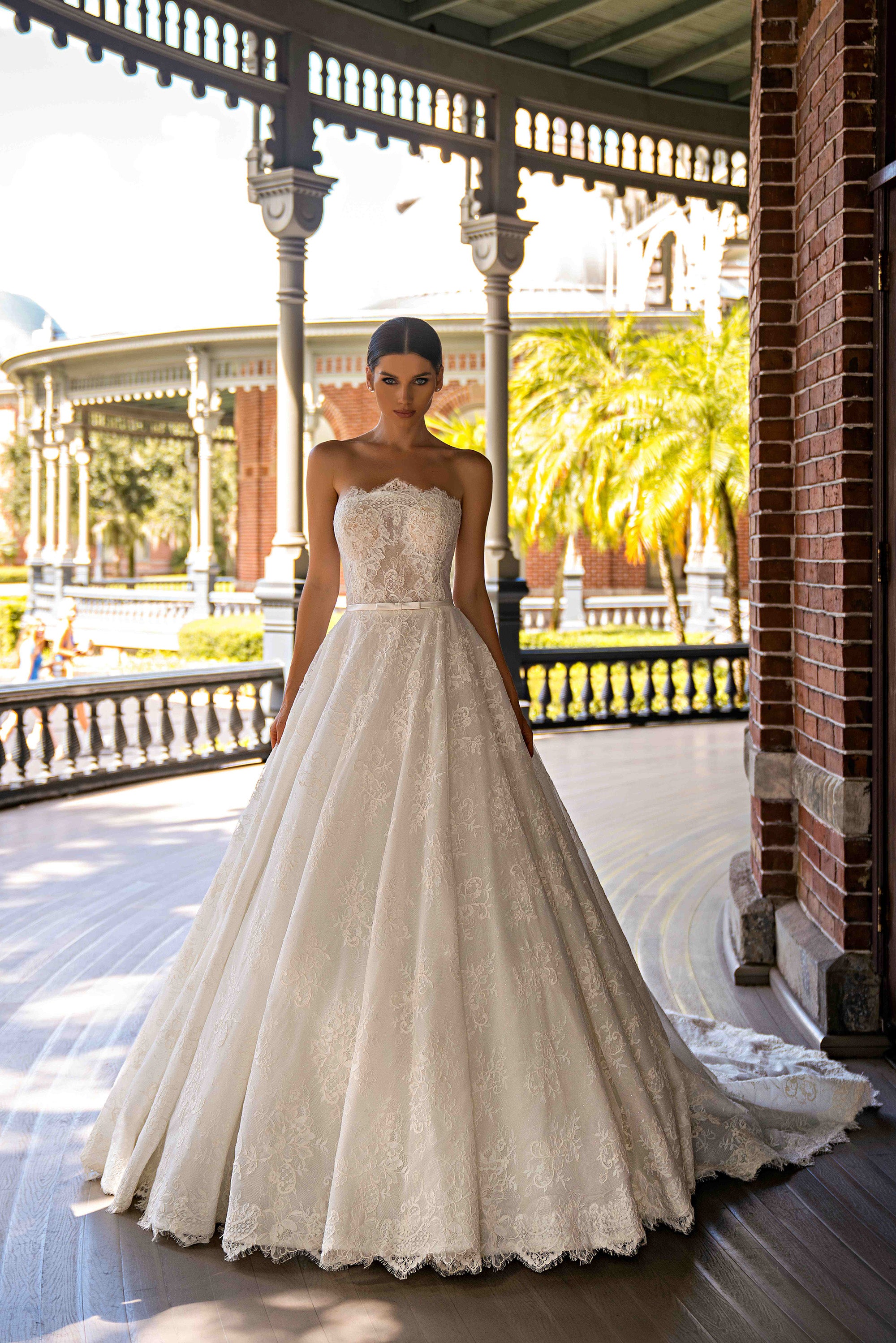 Strapless ivory wedding dress with a lace bodice, full A-line skirt, and scalloped hem