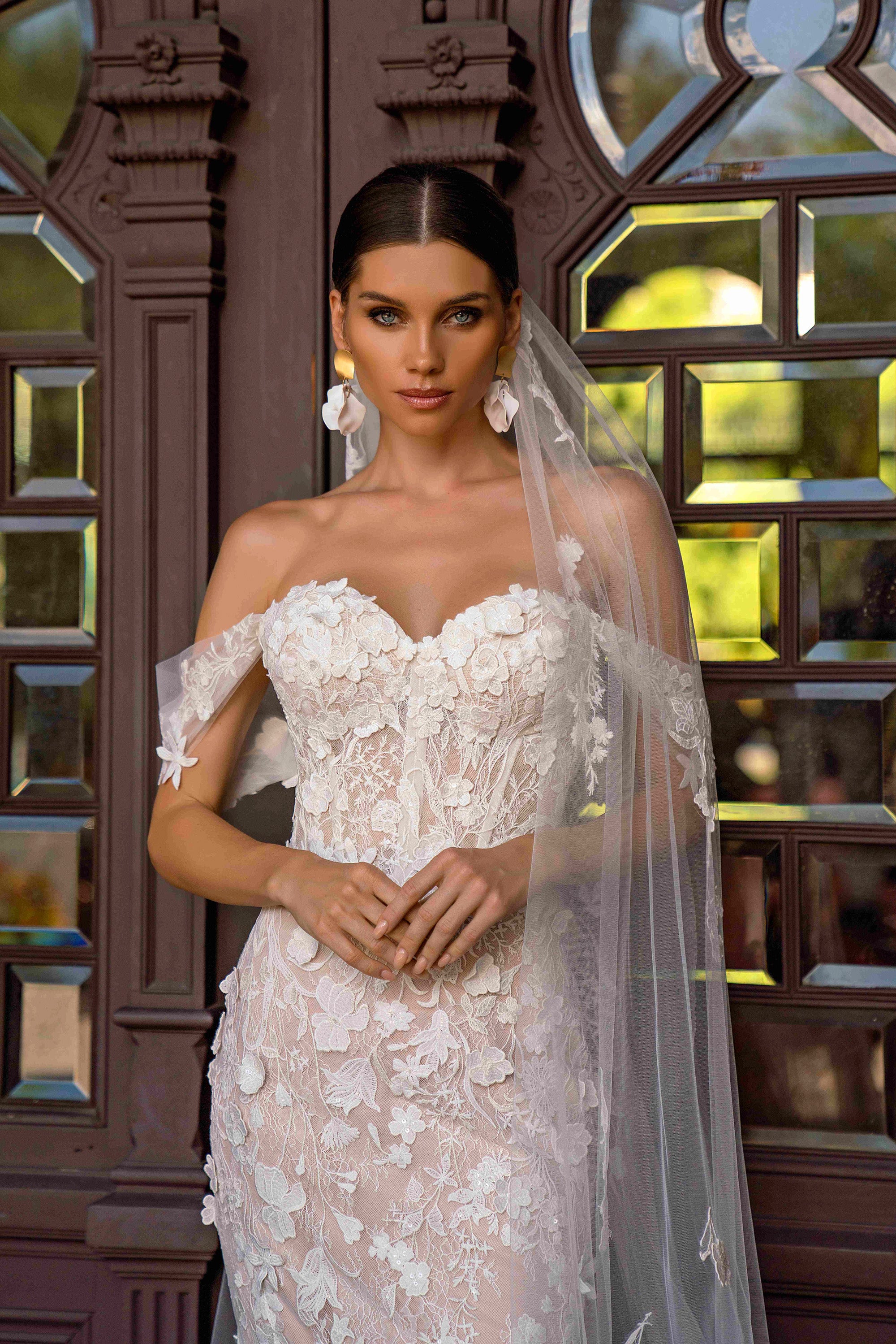 Ivory lace wedding dress with a sweetheart neckline, sheer off-shoulder sleeves, and floral appliqué detailing