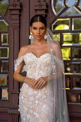 Ivory lace wedding dress with a sweetheart neckline, sheer off-shoulder sleeves, and floral appliqué detailing