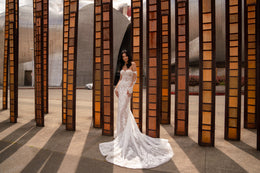 Full-length ivory wedding dress with a fitted mermaid silhouette, floral lace, and a flowing train