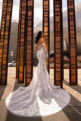 Open-back ivory mermaid wedding dress with long lace sleeves and a dramatic sweeping train
