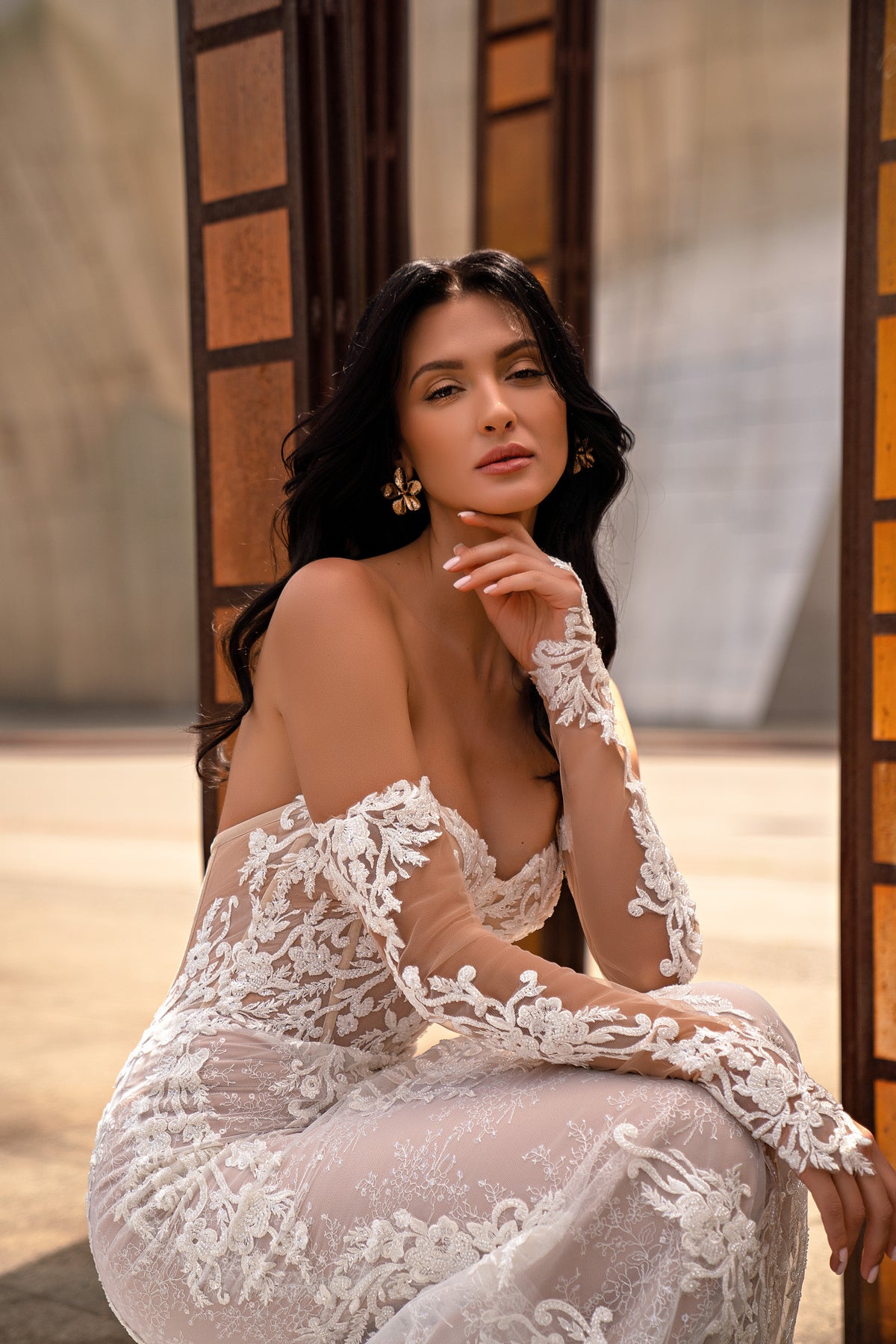 Close-up of an ivory wedding dress with a sweetheart neckline and sheer floral lace sleeves