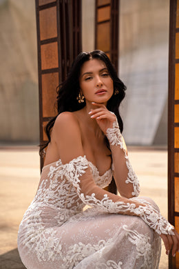Close-up of an ivory wedding dress with a sweetheart neckline and sheer floral lace sleeves