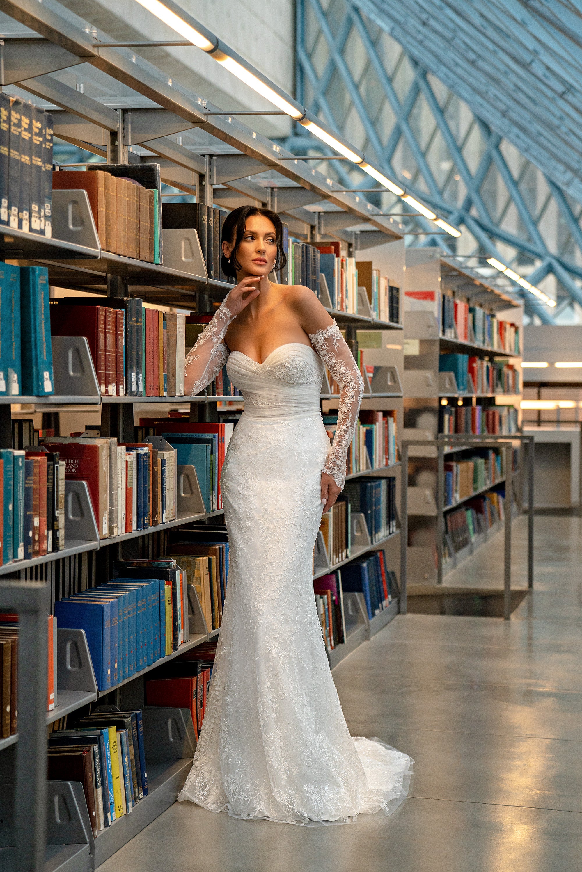 Ivory mermaid wedding dress with a sweetheart neckline, sparkling lace sleeves, fitted bodice, and trailing train
