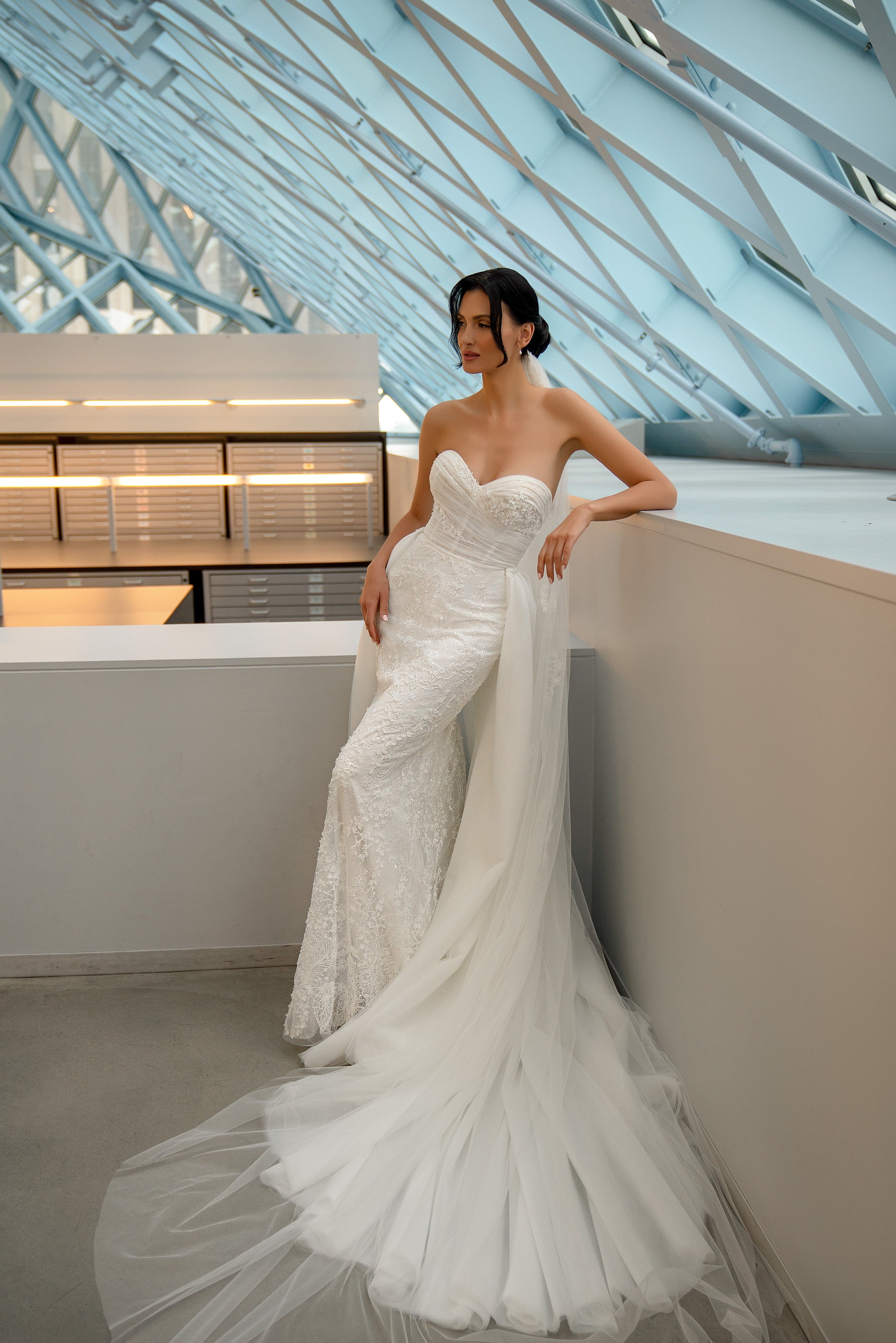 Strapless ivory mermaid wedding dress with a sweetheart neckline, fitted lace skirt, and dramatic tulle train