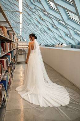 Open-back ivory wedding dress with a long sheer flowing train and fitted mermaid skirt