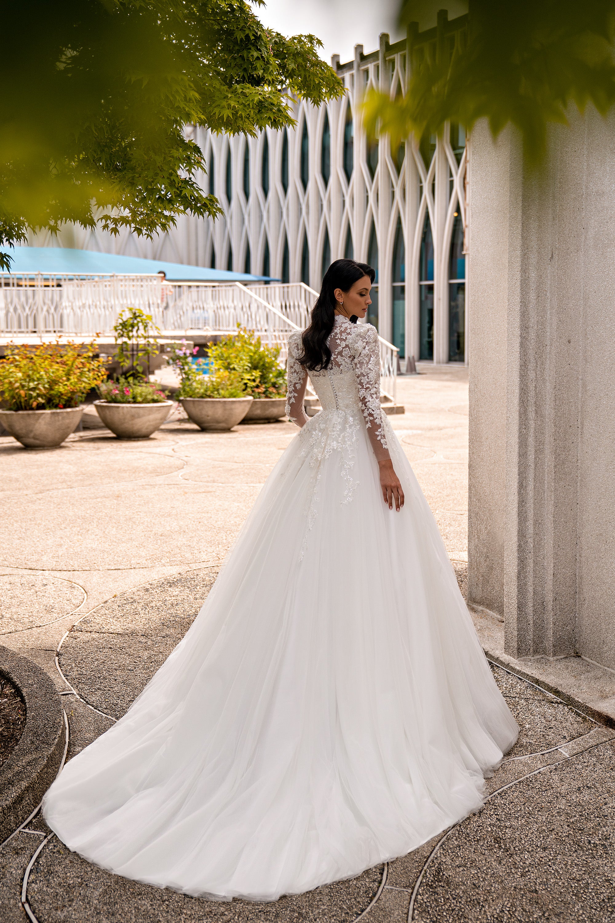 Ivory wedding dress with long lace sleeves, a fitted bodice, A-line skirt, and sweeping train