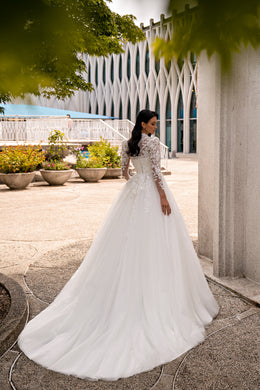 Ivory wedding dress with long lace sleeves, a fitted bodice, A-line skirt, and sweeping train