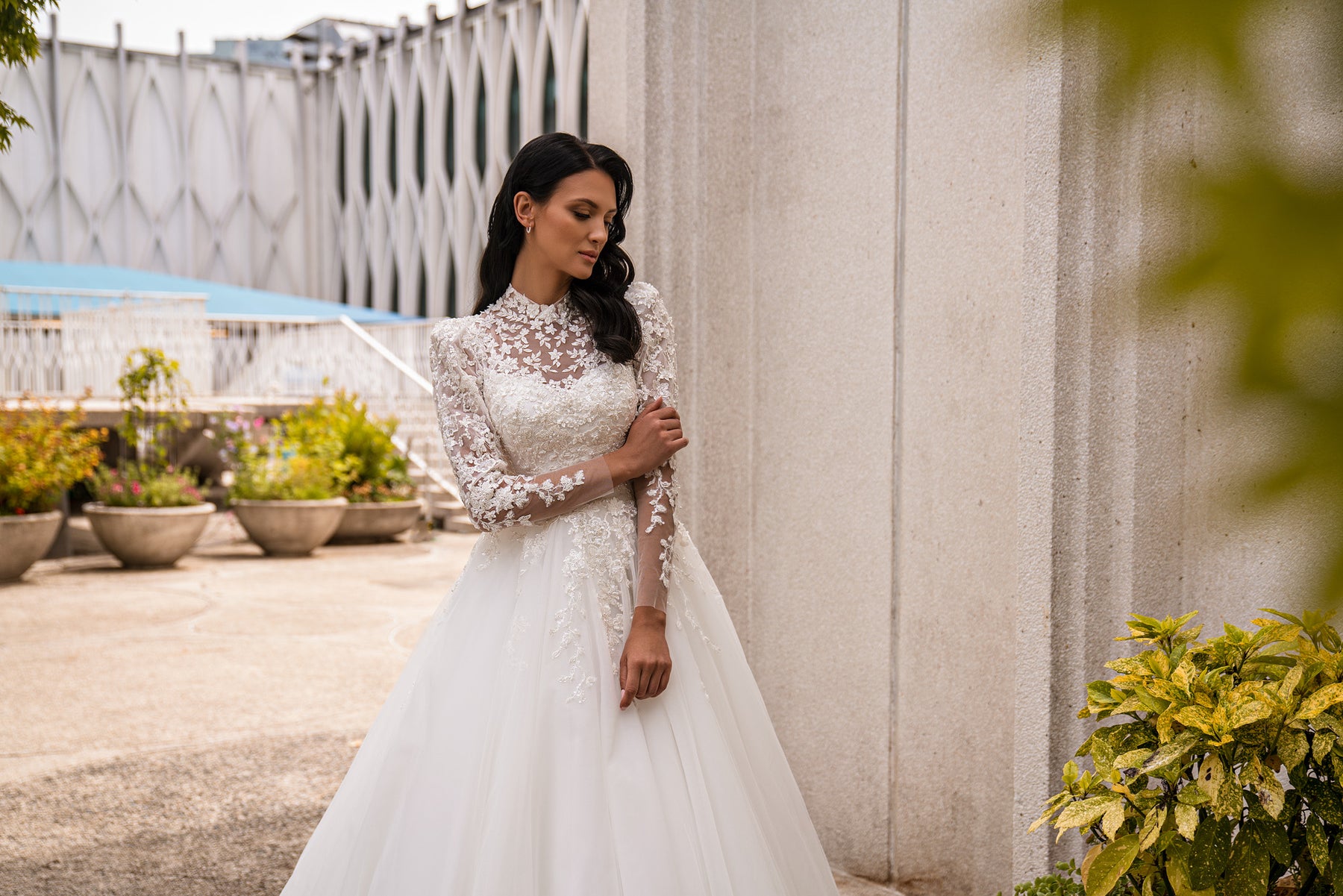 Close-up of floral lace and sparkling beadwork on the high-neck bodice of an ivory wedding dress