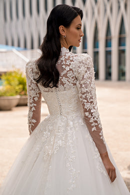 Back view of an ivory wedding dress with sheer floral lace sleeves and lace detailing across the bodice
