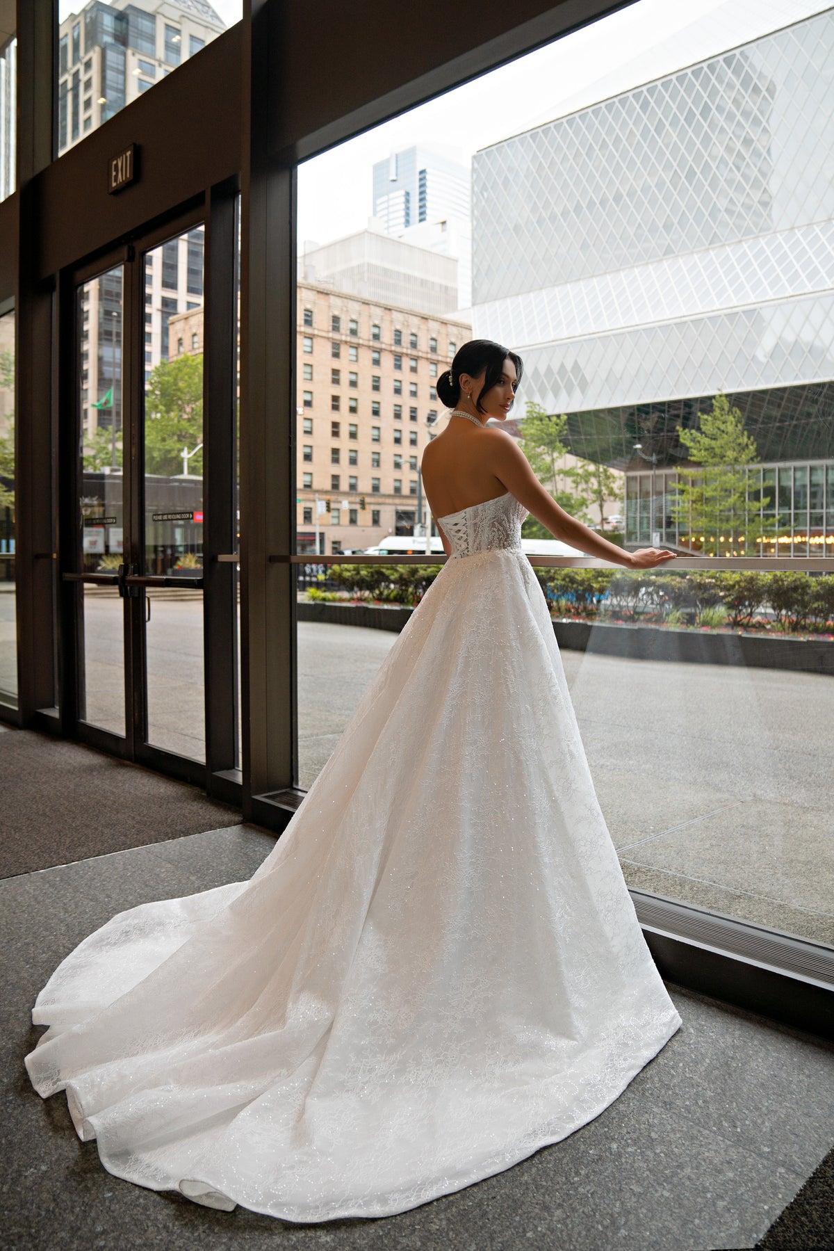Ivory strapless wedding dress with a full skirt and sweeping train, shown from the back