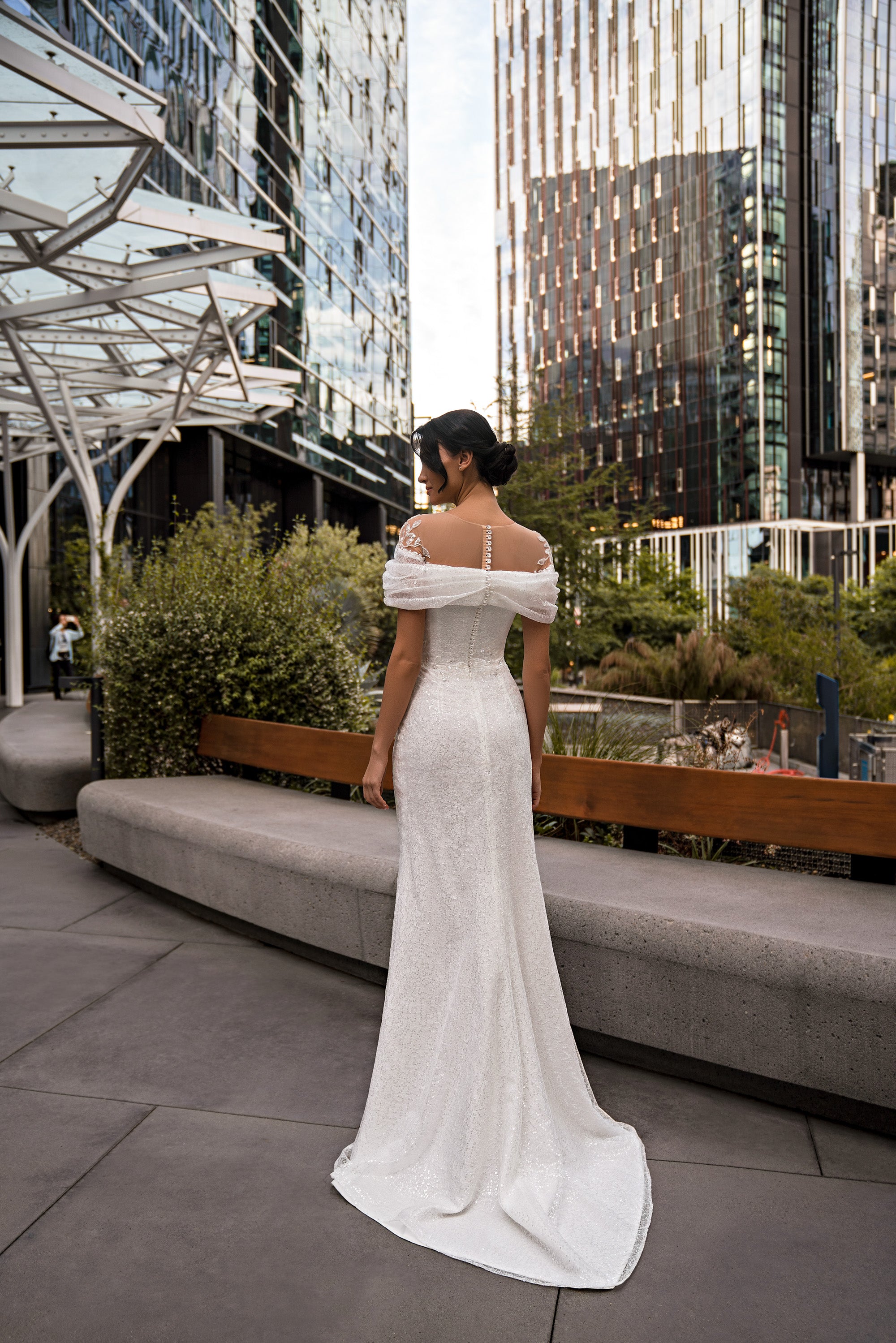 Ivory wedding dress showing its off-the-shoulder neckline, fitted back, and long sweeping train