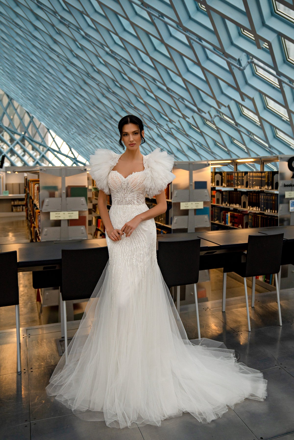 Ivory mermaid wedding dress with a deep V-neckline, embellished bodice, and detachable tulle puff sleeves