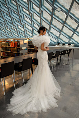 Ivory mermaid wedding dress with voluminous tulle puff sleeves, fitted waist, and a sweeping train