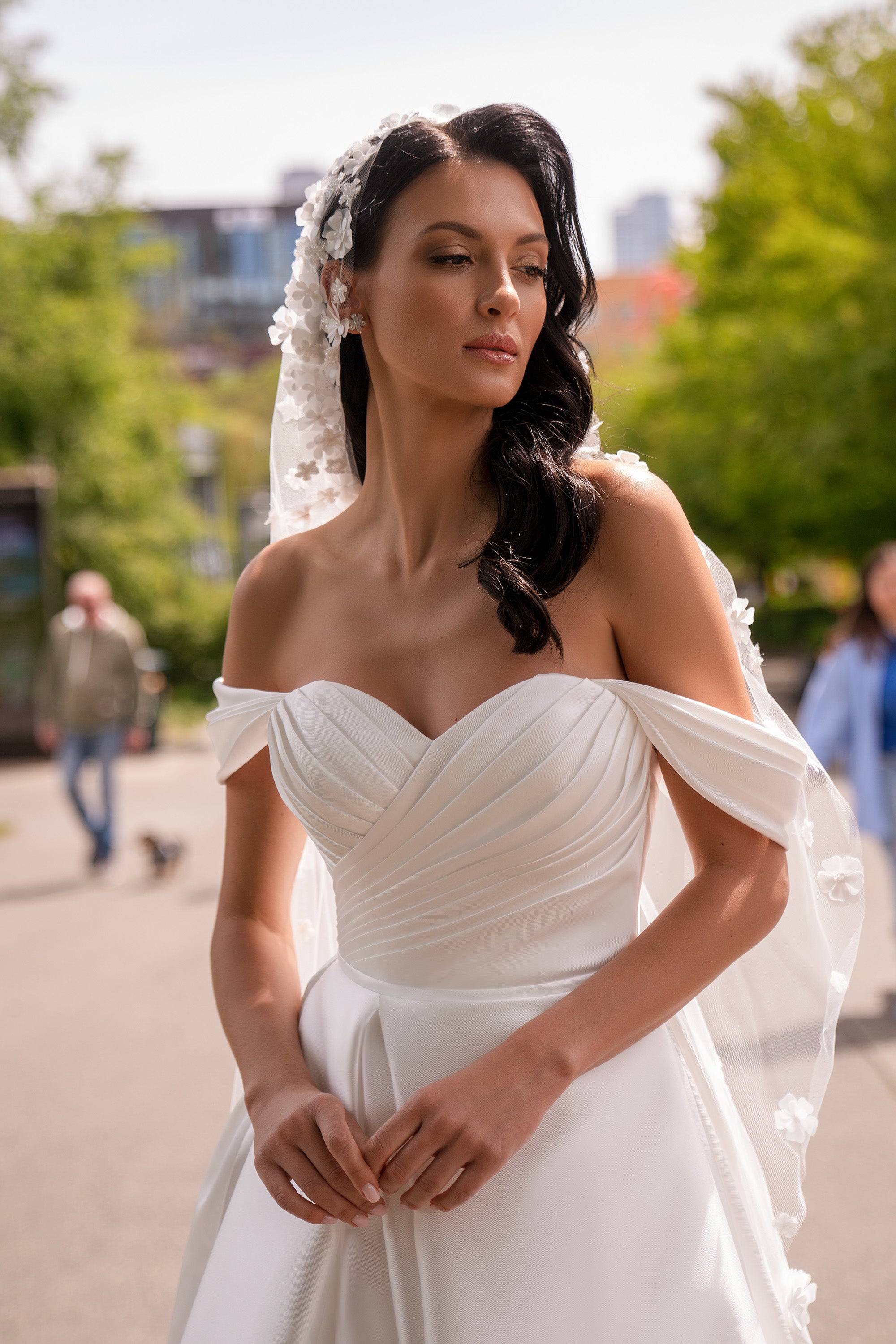 Ivory wedding dress with a draped sweetheart bodice and delicate off-the-shoulder straps