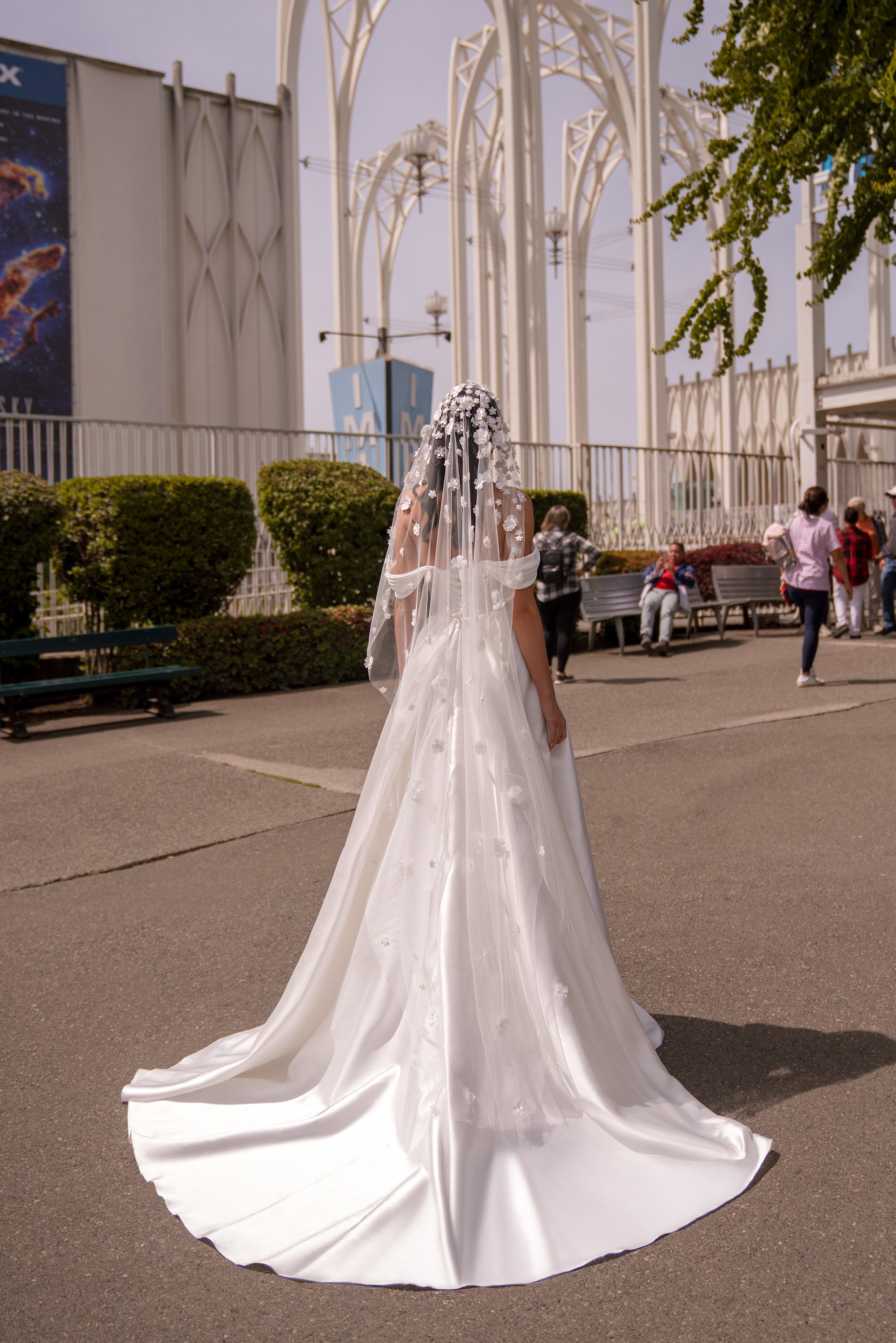 White wedding dress shown from the back with a long sweeping train and fitted waist
