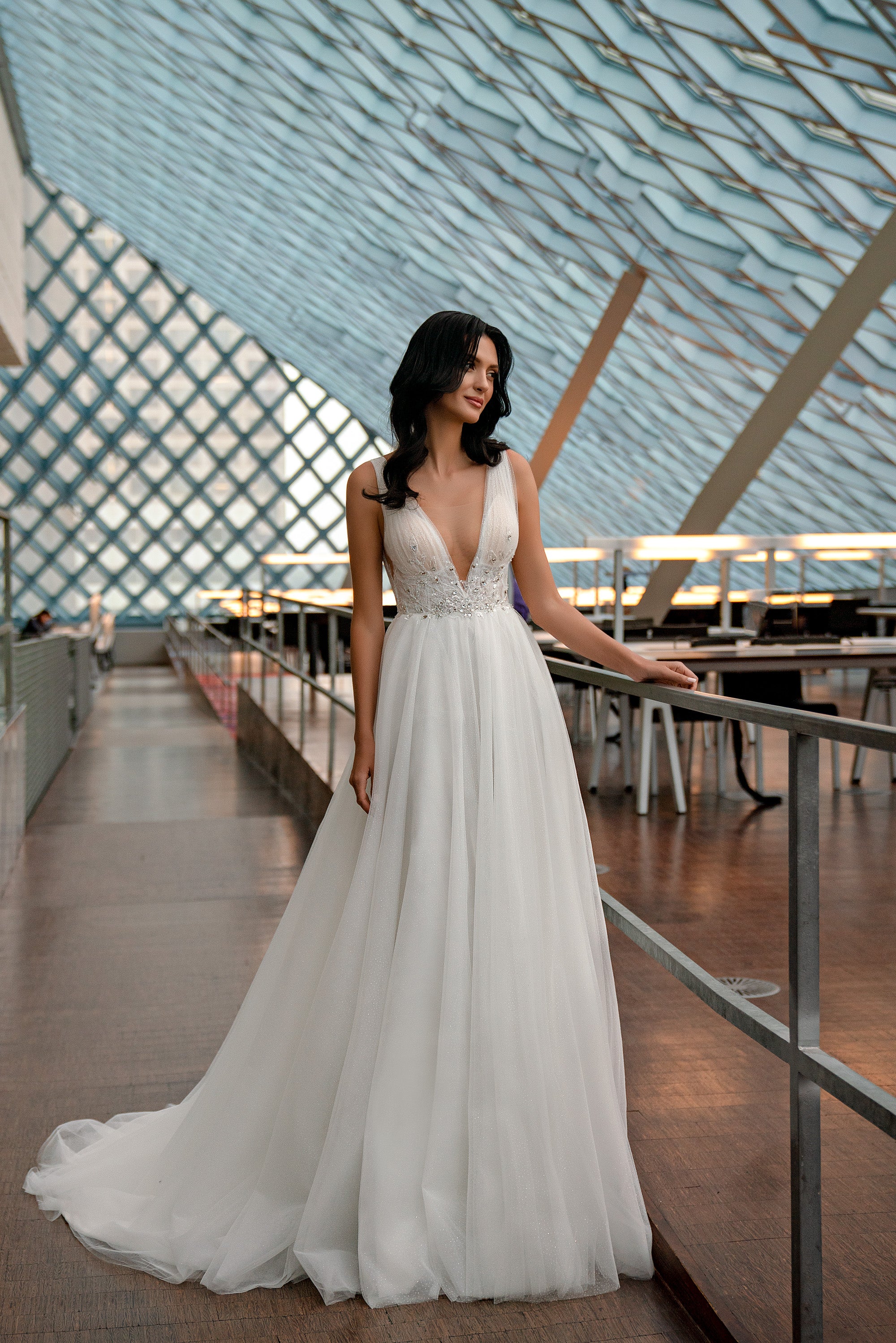 Ivory wedding dress with a beaded V-neck bodice, slender straps, and softly glittered full skirt