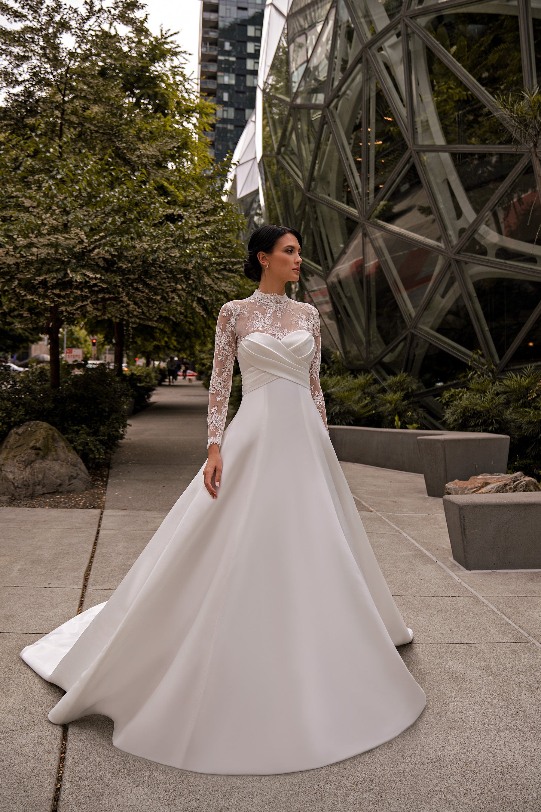 Ivory A-line wedding dress with a sweetheart bodice, sheer lace sleeves, and a sweeping train